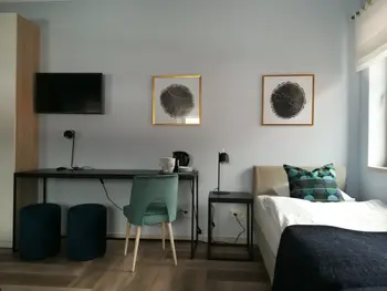 Wnętrze pokoju z biurkiem, telewizorem i łóżkiem w stylu minimalistycznym, nowoczesnym, współczesnym.