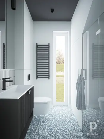 Nowoczesna łazienka z białą umywalką, czarnymi detalami i minimalistycznym designem.