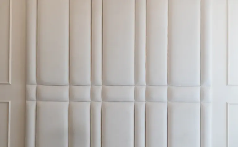 Wnętrze sypialni z beżowym zagłówkiem, szarymi poduszkami, styl art deco, nowoczesny, quiet luxury.