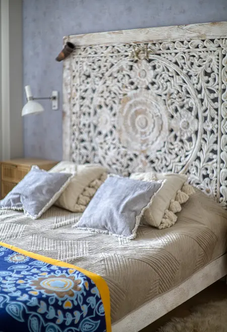 Sypialnia w stylach boho, japandi i vintage z dekoracyjnym zagłówkiem.