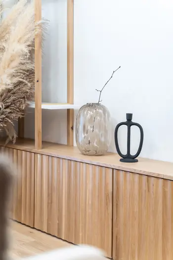 Stylowe wnętrze z boho i minimalistycznymi akcentami, prezentujące drewniane meble.