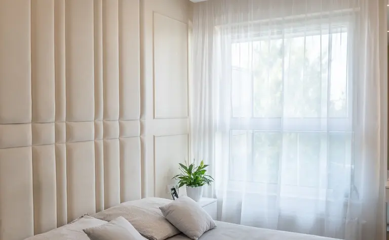 Wnętrze sypialni z jasnymi ścianami, nowoczesnym łóżkiem i rośliną. Styl art deco, quiet luxury, tradycyjny.