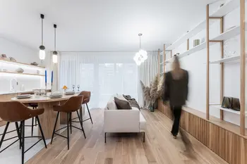 Wnętrze w stylu boho, japandi, minimalistycznym z jasnym stołem i brązowymi krzesłami.