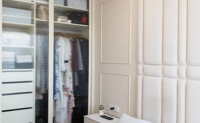 Wnętrze sypialni z białą szafą, szarym łóżkiem i nowoczesnym oświetleniem. Styl: art deco, nowoczesny, quiet luxury, tradycyjny, współczesny.