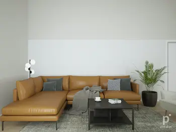 Wnętrze salonu w stylu skandynawskim z brązową sofą, czarnym stolikiem i rośliną.