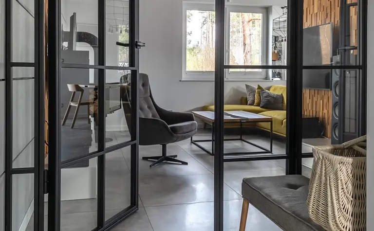 Przedpokój w stylu industrialnym i minimalistycznym z szarymi płytkami i drewnianymi akcentami.