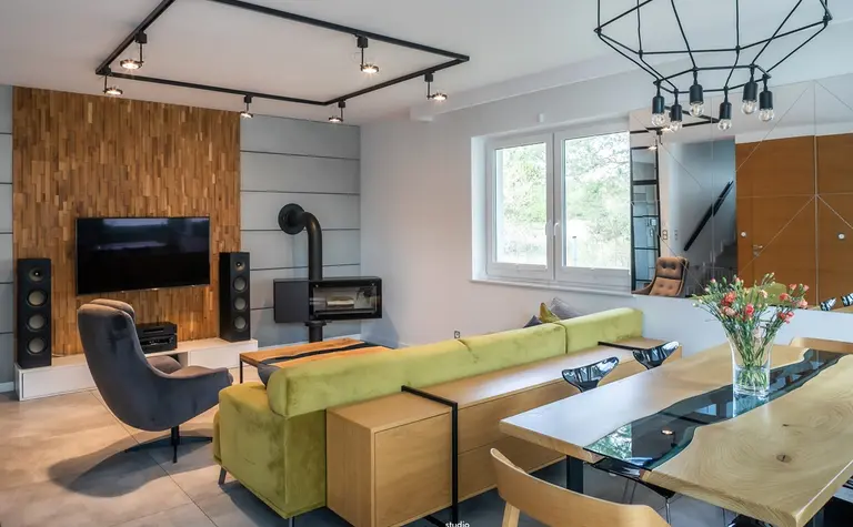 Wnętrze salonu w stylu industrialnym i skandynawskim z drewnianą ścianą.