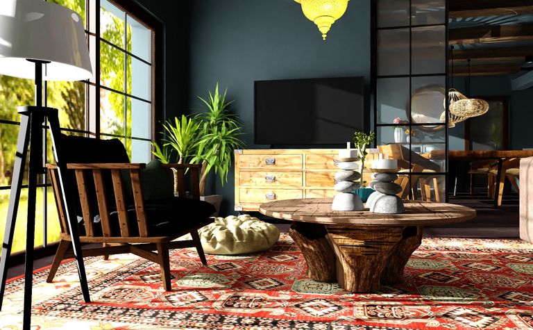Salon w stylu boho z drewnianym stołem, lampą i roślinami