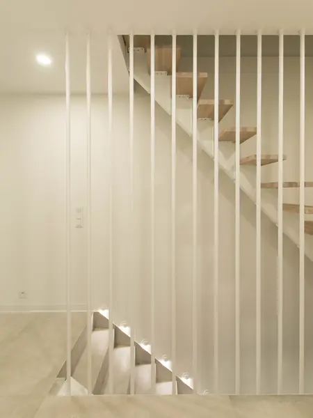 Nowoczesne schody minimalistyczne z drewnem i białymi balustradami.