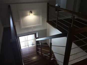 Widok korytarza z drewnianymi schodami, nowoczesny i tradycyjny design.