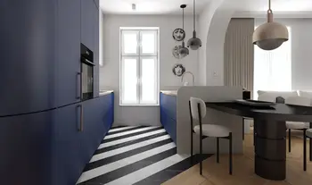 Wnętrze kuchni z granatowymi meblami, czarnym blatem i nowoczesnymi lampami
