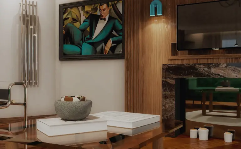 Wnętrze salonu w stylu art deco z zieloną sofą i drewnianymi detalami.