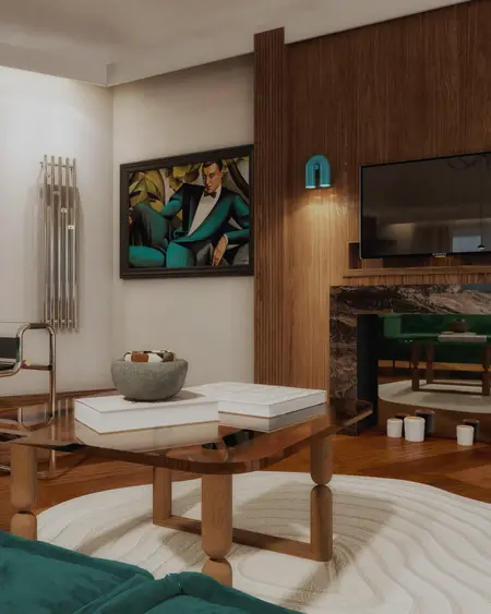 Wnętrze salonu w stylu art deco z zieloną sofą i drewnianymi detalami.