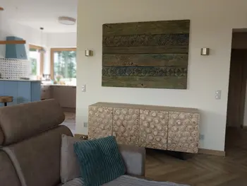 Wnętrze eklektycznego salonu z drewnianymi meblami i nowoczesnymi akcentami.