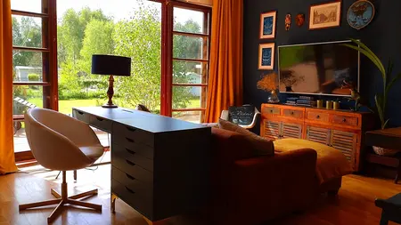 Wnętrze salonu z brązowymi meblami, dużymi oknami i roślinami, styl boho, eklektyczny, rustykalny