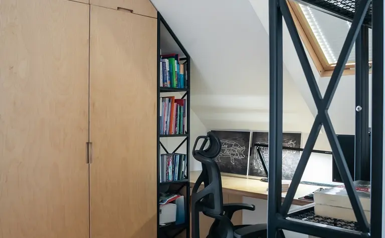 Gabinet w stylu industrialnym z drewnianymi meblami i minimalistycznym oświetleniem.