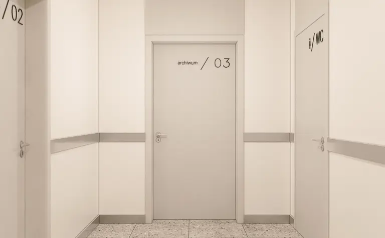 Korytarz w minimalistycznym stylu z szarymi ścianami i nowoczesnymi drzwiami.
