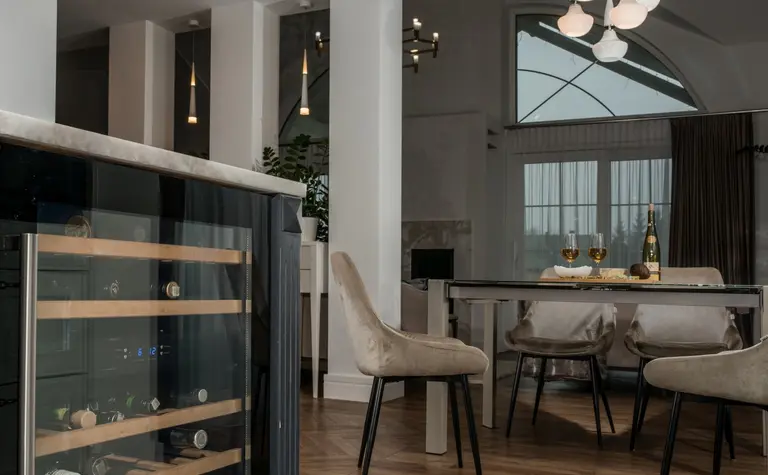 Wnętrze jadalni z nowoczesnym stołem i tradycyjnymi krzesłami w stylu quiet luxury.