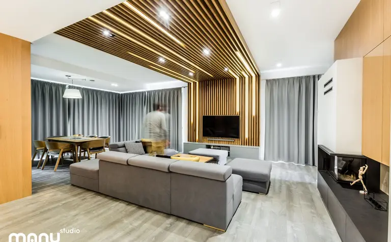 Salon w stylu industrialnym z minimalistycznym wystrojem i drewnianymi akcentami.