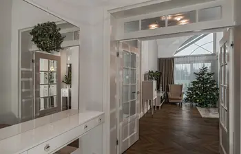 Przedpokój z białymi meblami, drewnianą podłogą i choinką. Styl nowoczesny, quiet luxury, tradycyjny.