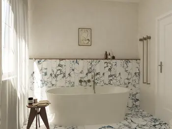 Wnętrze łazienki w stylu soft minimalizm i vintage z wanną oraz marmurowymi płytkami.