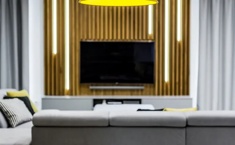 Salon w stylu industrialnym z minimalistycznym oświetleniem i drewnianą dekoracją.