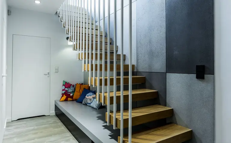 Wnętrze wejścia z industrialnymi schodami, minimalistycznym designem i skandynawskimi detalami.