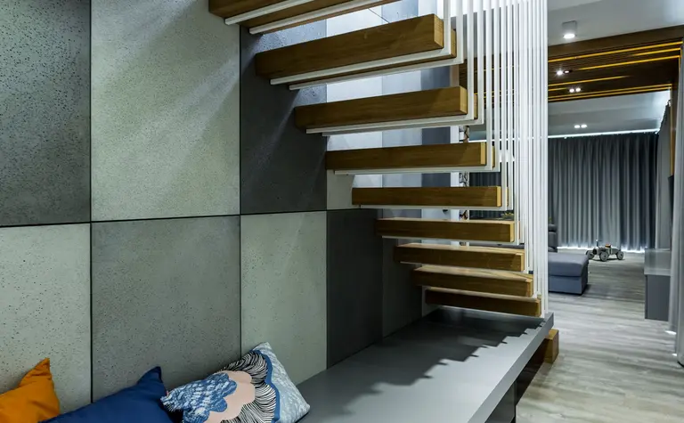 Wnętrze z drewnianymi schodami i poduszkami w stylu industrialnym, minimalistycznym i skandynawskim.