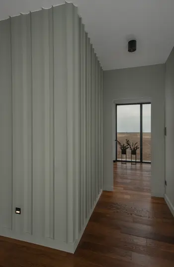 Korytarz w stylu minimalistycznym z zielonymi ścianami i drewnianą podłogą, nowoczesny design.