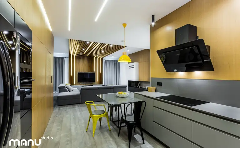 Wnętrze kuchni w stylu industrialnym i skandynawskim z drewnianymi detalami i nowoczesnym oświetleniem.