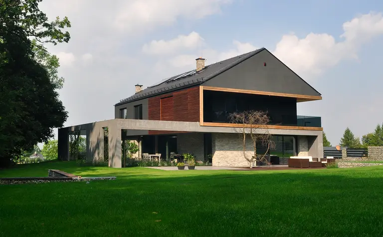 Widok nowoczesnego domu z dużymi oknami i ogrodem, styl minimalistyczny i minimaluxe.