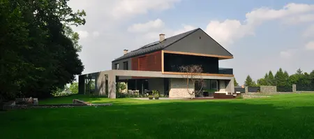 Widok nowoczesnego domu z dużymi oknami i ogrodem, styl minimalistyczny i minimaluxe.