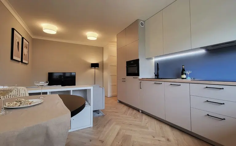 Wnętrze kuchni w stylu japandi, minimalistycznym i skandynawskim z jasnymi meblami.