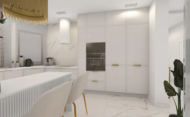 Nowoczesna kuchnia z białymi meblami, złotymi detalami i eleganckim oświetleniem.