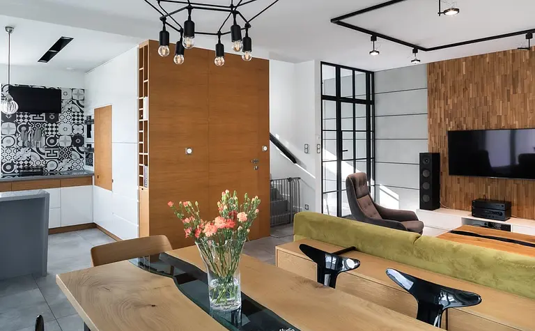 Wnętrze salonu w stylu industrialnym z minimalistycznym wystrojem, drewnianą ścianą i nowoczesnymi akcentami.