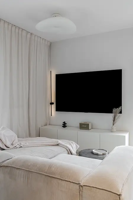 Wnętrze salonu w stylu art deco i boho z białą sofą.