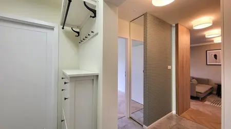 Przedpokój w stylu japandi, minimalistycznym i skandynawskim z białymi meblami.