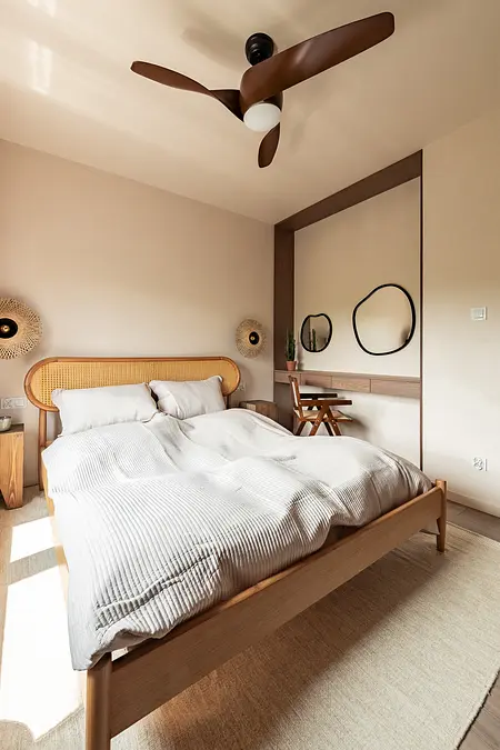Sypialnia w stylu boho i japandi z drewnianym łóżkiem i minimalistycznym wystrojem.