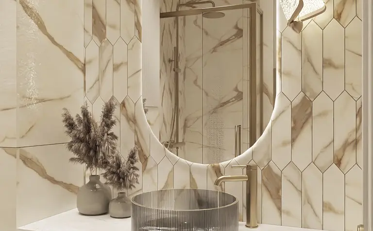 Nowoczesna łazienka z beżowymi płytkami, elegancką umywalką i złotymi detalami.