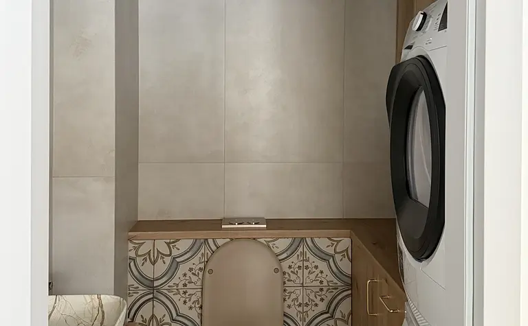 Wnętrze łazienki z drewnianymi meblami i kolorowymi płytkami w stylu boho i nowoczesnym.