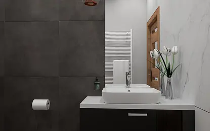 Wnętrze łazienki w stylu art deco z szarymi płytkami i białą umywalką.