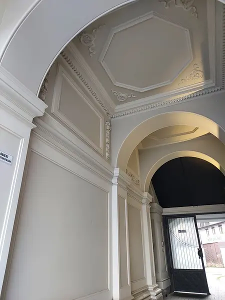 Wnętrze z eleganckim sufitem i architektonicznymi detalami.