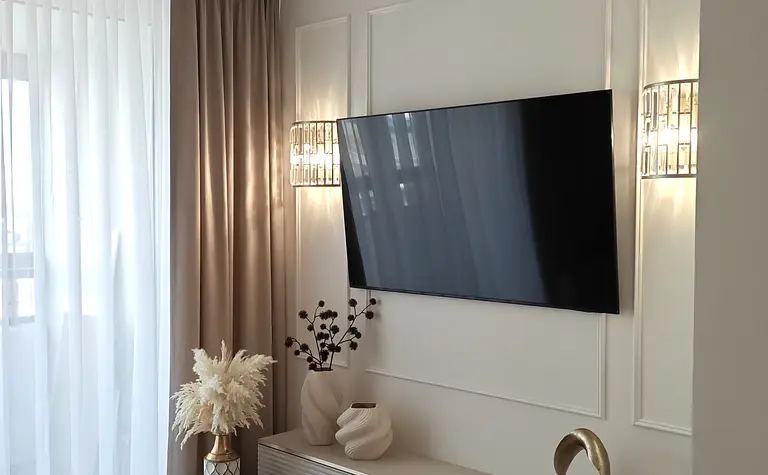 Wnętrze salonu z elementami art deco, glamour i nowoczesnymi dodatkami.