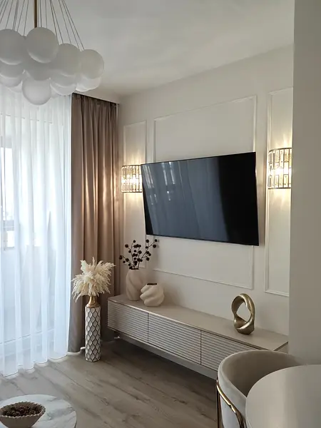 Wnętrze salonu z elementami art deco, glamour i nowoczesnymi dodatkami.