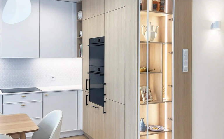 Kuchnia w stylu glamour, japandi i minimalistycznym z białymi meblami i drewnianymi detalami.