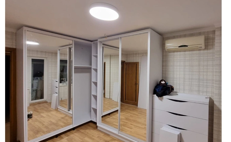 Garderoba w stylu minimalistycznym z lustrami i białymi meblami.
