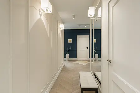 Przedpokój z minimalistycznym designem, białymi ścianami i ciemnym akcentem.