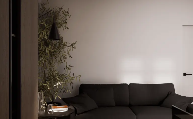 Wnętrze salonu w stylu minimalistycznym z ciemną sofą i drewnianą podłogą.