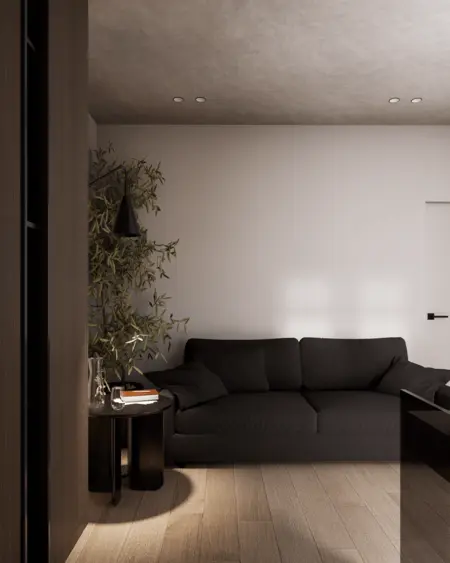 Wnętrze salonu w stylu minimalistycznym z ciemną sofą i drewnianą podłogą.