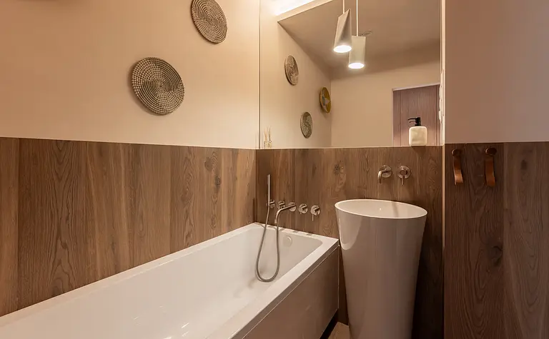 Wnętrze łazienki w stylu boho i rustykalnym z drewnianymi elementami.